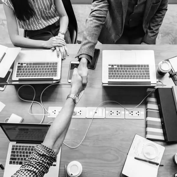 Shaking hands over work table